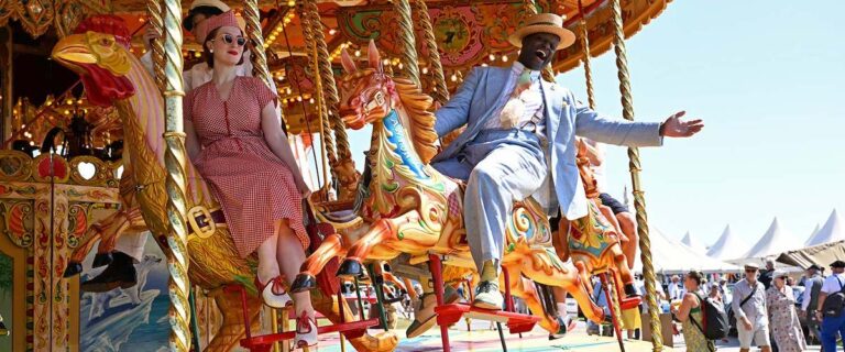 Visitors enjoying the vintage carousel at the Goodwood Revival.