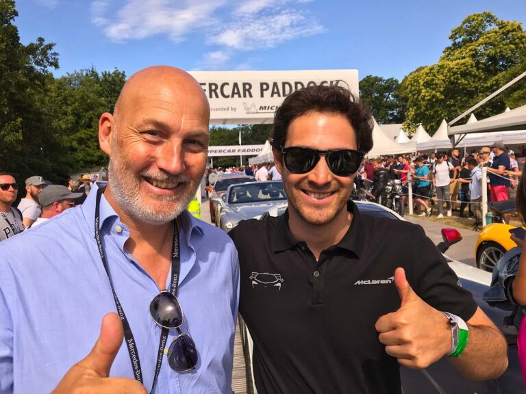 Visitor with a McLaren driver in the Supercar Paddock at the Goodwood Festival of Speed.