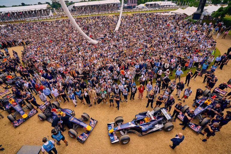 Formula One cars surrounded by fans at the Goodwood Festival of Speed.