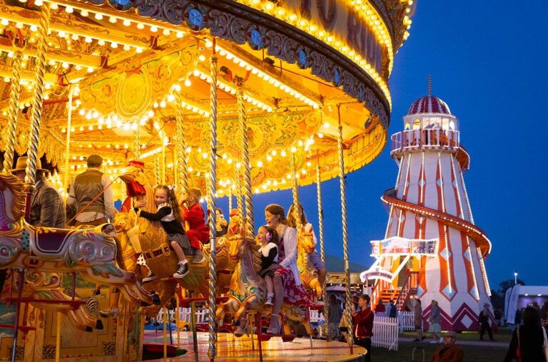 Historisches Karussell auf dem Jahrmarkt des Goodwood Revival bei Nacht.