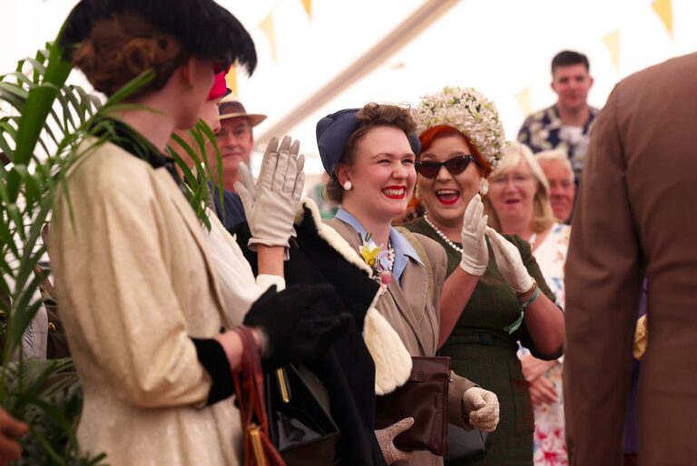 Visitors wearing elegant 1940s and 1950s fashion at the Goodwood Revival.