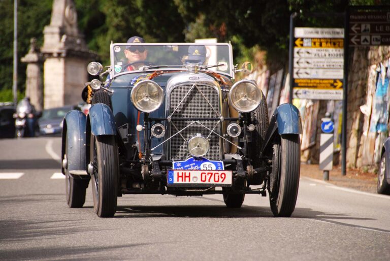 Historic Mercedes-Benz touring car competing in the Gran Premio Nuvolari on an Italian country road.