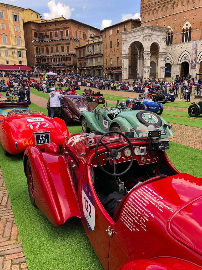Historic racing cars on Siena's Piazza del Campo during the Mille Miglia.