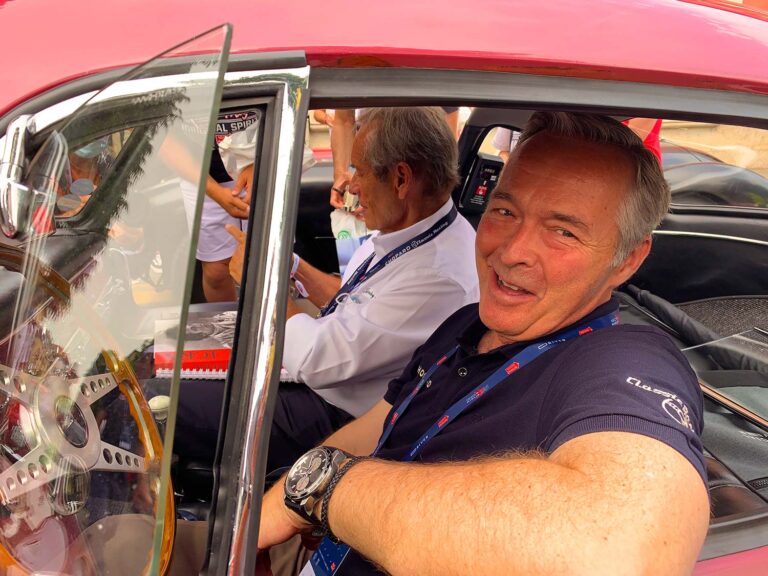 Participant enjoying the cockpit of a classic Ferrari during the Mille Miglia, Italy's legendary historic road rally.