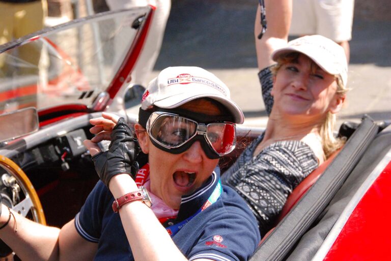 Two participants enjoying the ride in a classic roadster during the Mille Miglia.