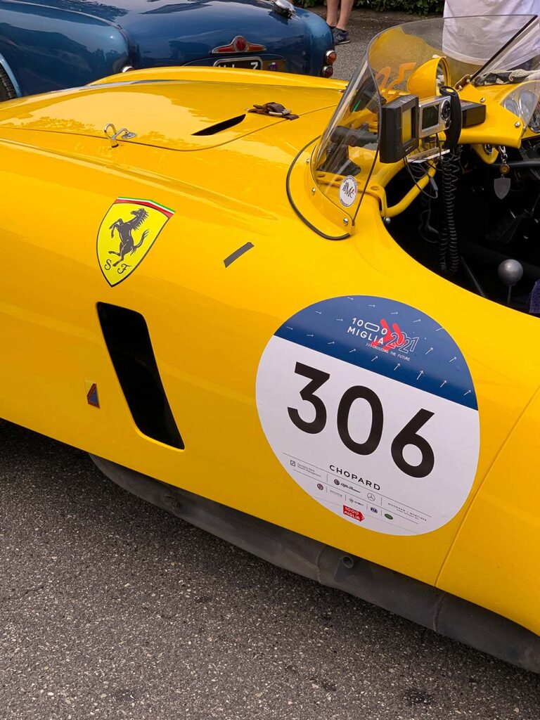 Close-up of a yellow Ferrari with Mille Miglia race number.