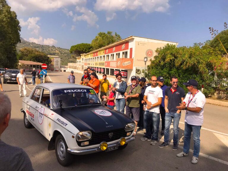 Classic Peugeot 204 Rallye arriving at the historic Cerda grandstand during the Targa Florio in Sicily.