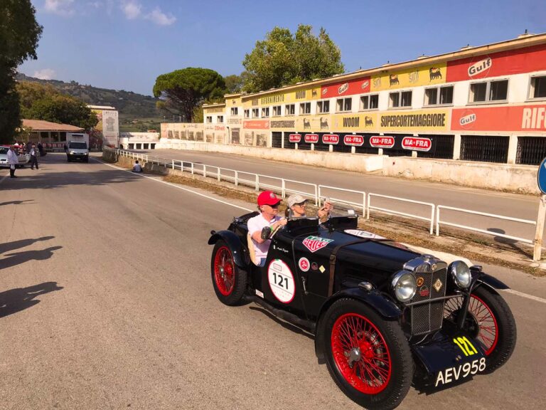 Historic British roadster passing the Cerda grandstand on Sicily's legendary Targa Florio route.
