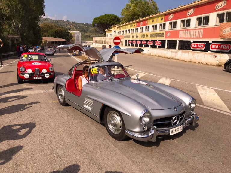 Mercedes-Benz 300 SL Gullwing and Alfa Romeo Giulia Sprint GT at the historic Cerda grandstand on Sicily's Targa Florio route.