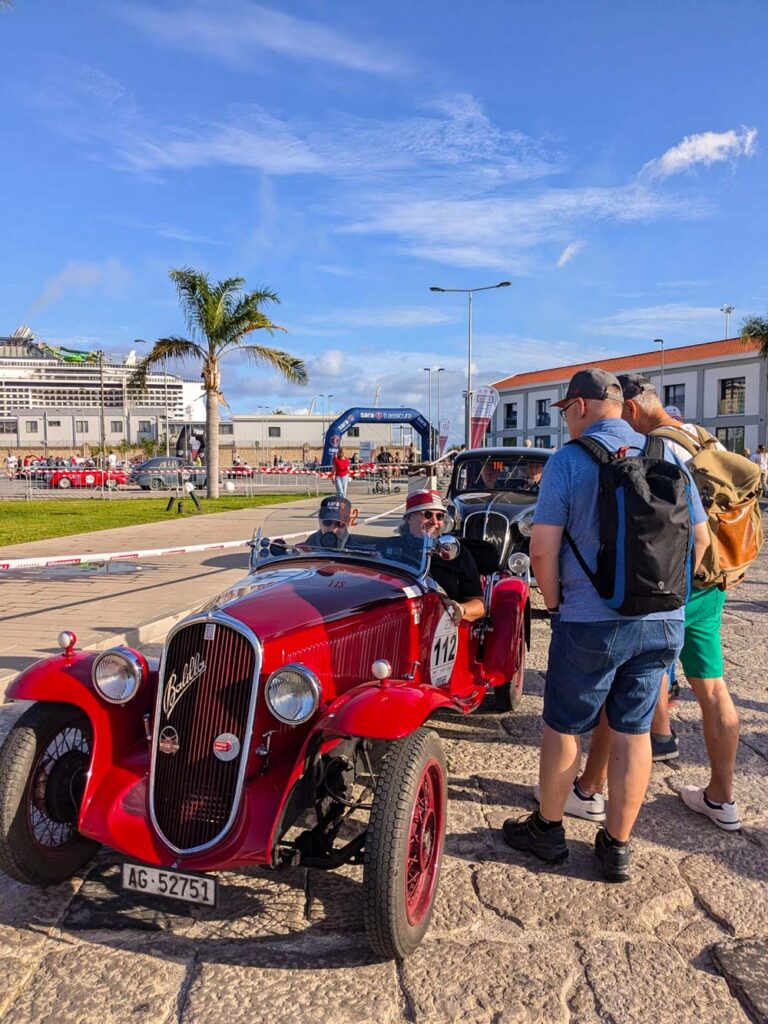 Historic Alfa Romeo pre-war racing car with participants at the Targa Florio start area in Palermo, Sicily.