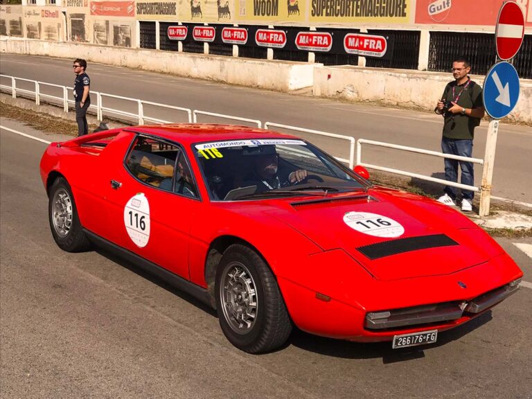 Red Maserati Merak at Targa Florio Live beside the historic Cerda pit buildings in Sicily.