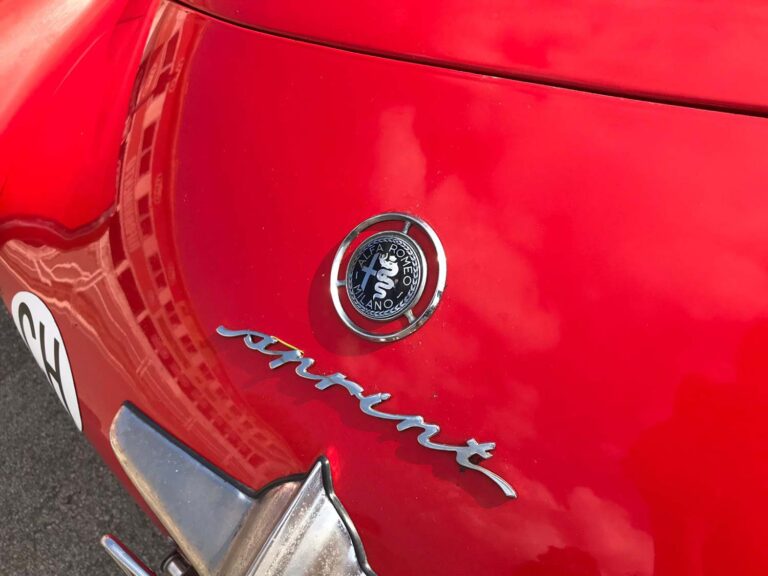 Alfa Romeo badge and Pininfarina script on a classic red Alfa Romeo.